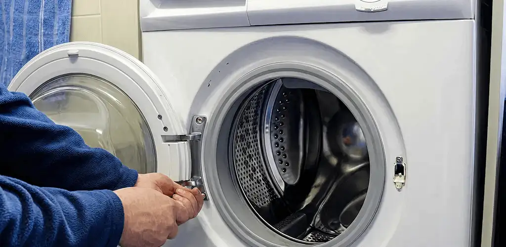 Washing machine repair handyman checking a front-load washer door and latch in Aurora, CO