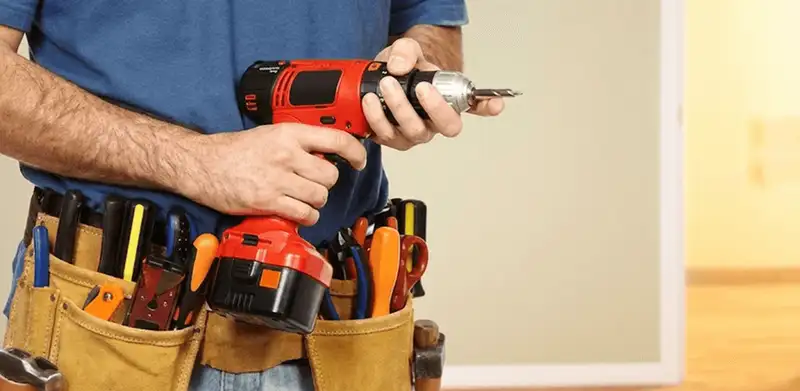 Handyman holding a power drill for home repairs and installations in Aurora, CO