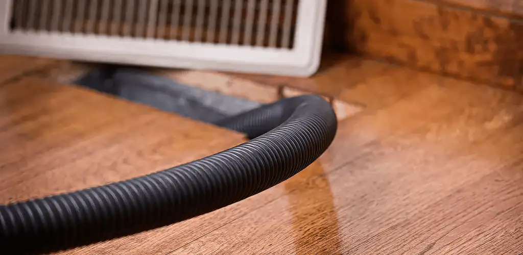 Air duct cleaning hose inserted into a floor vent for ductwork cleaning in Aurora, CO