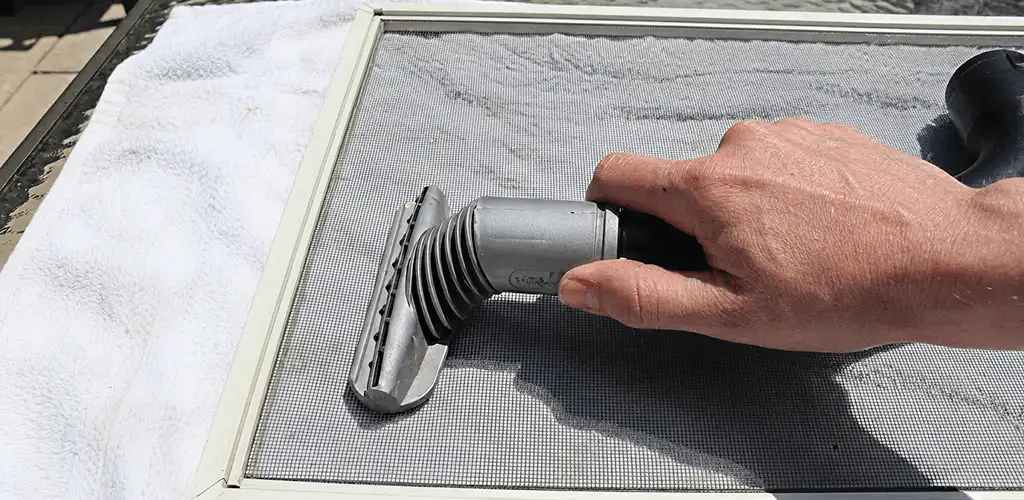 Window screen repair cleaning and fixing a damaged screen mesh in Aurora, CO